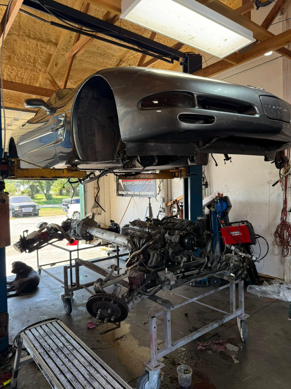 Corvette on the lift with engine pulled at Sagi Speed Shop